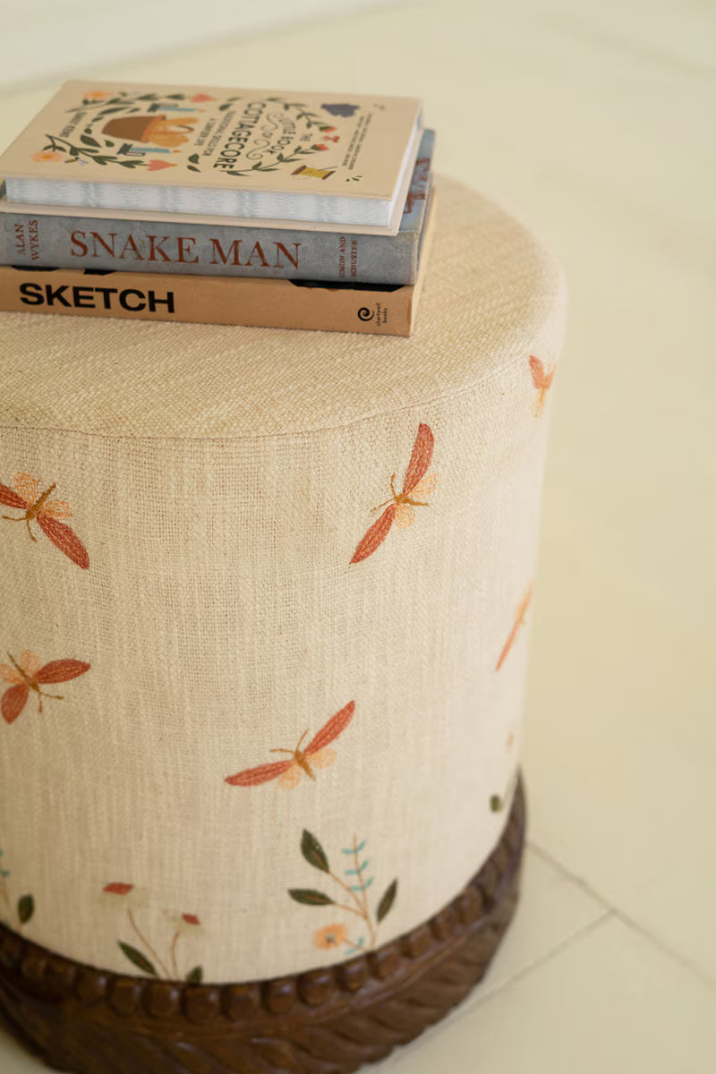 Cream Upholstered Ottoman with Embroidered Detail and Carved Wood Base